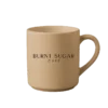 A caramel mug with Burnt Sugar's text logo.